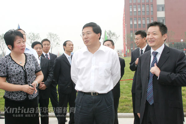 新華電腦教育負責人(右)向吳市長(中)介紹新校區建設情況