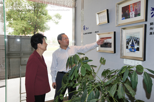 安徽新華電腦專修學院何貴金院長正在向謝秘書長介紹學院歷年來榮獲的榮譽和獎牌