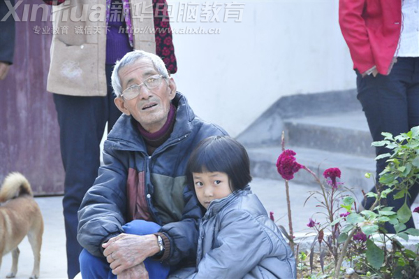 留守兒童偎依在爺爺的懷里怯怯地眼神卻透露出想參與游戲的渴望