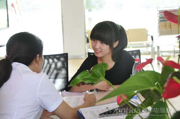 安徽新華電腦專修學院專業的咨詢老師為前來報名的學生講解專業