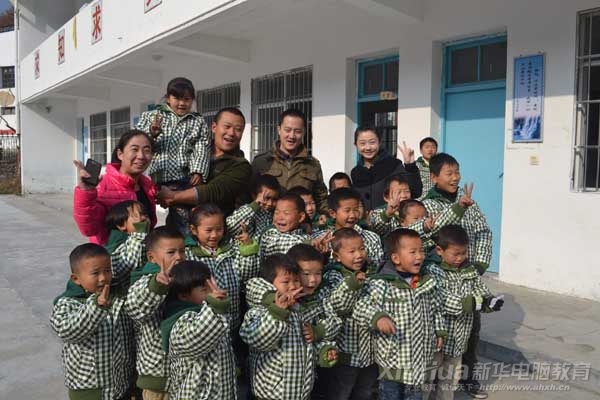 安徽新華電腦專修學院的愛心幫扶人員和白際小學的學生合影留念